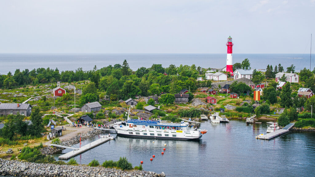 M/S Jenny kiinnittyneenä Tankarin majakkasaaren satama-altaan laituriin. Tankarin puna-valkoraitainen majakka odottelee jo vieraitaan.